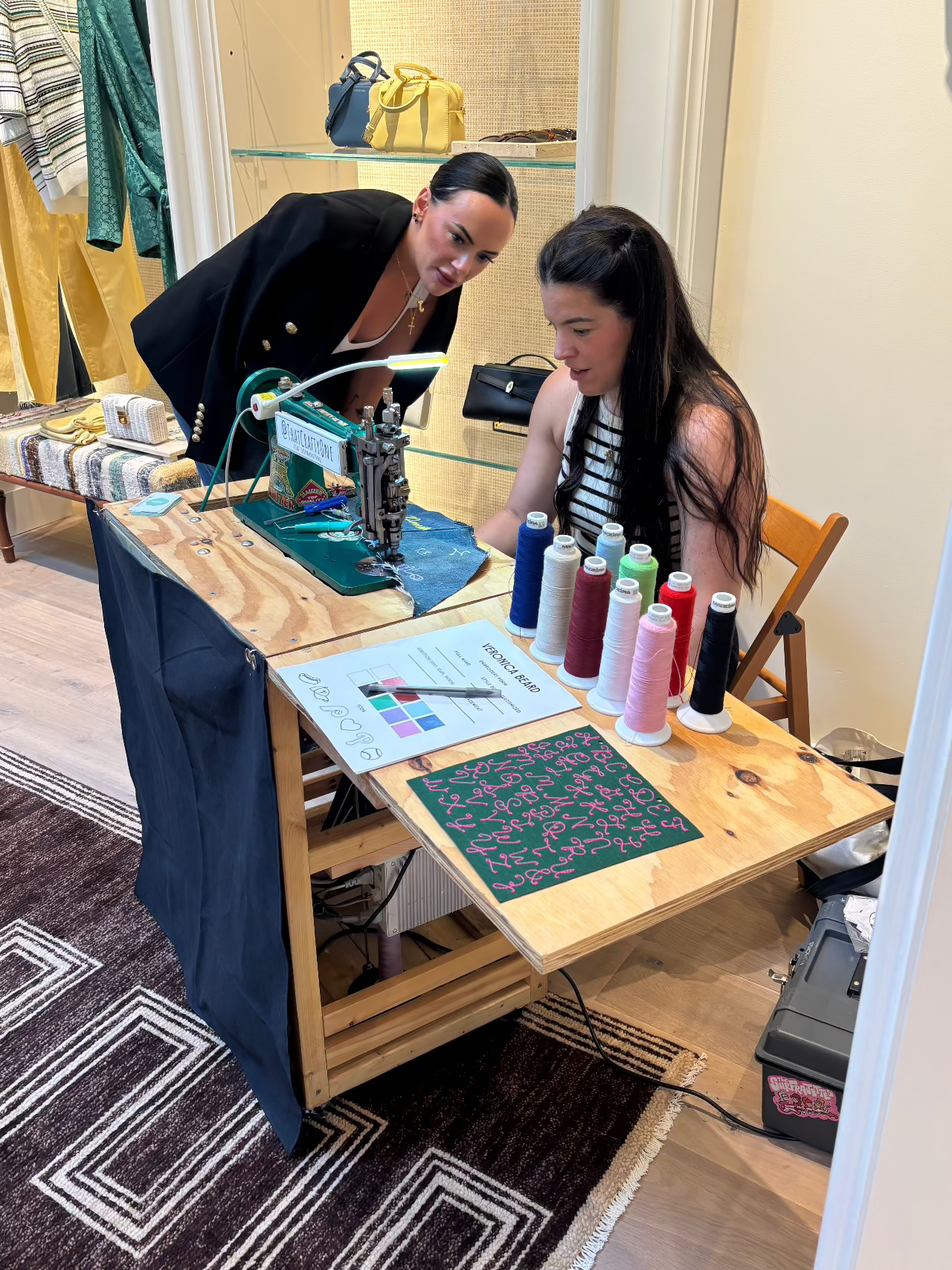That Crafty One at a chainstitch embroidery retail activation interacting with guests and explaining her craft as she customizes apparel.