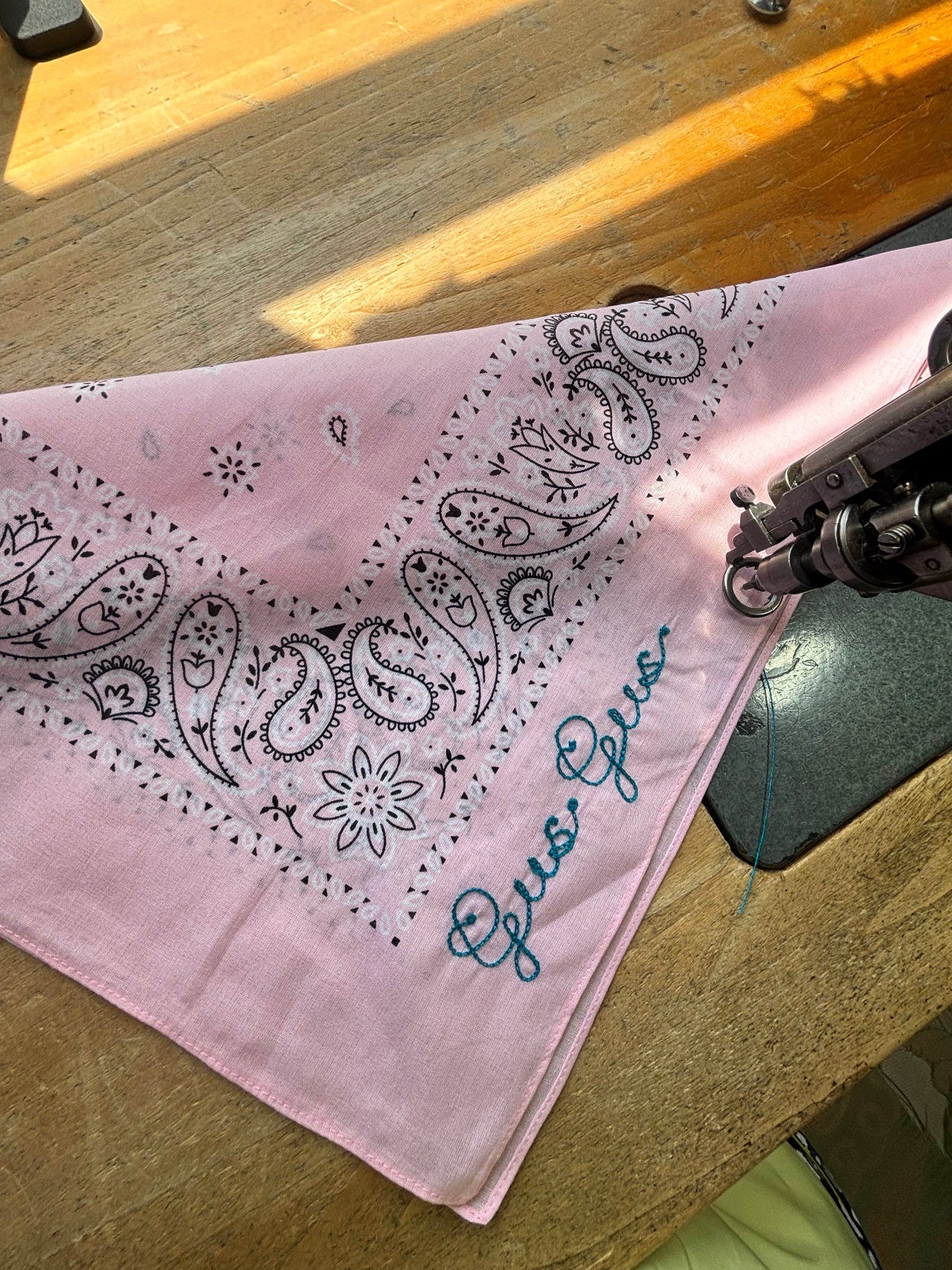 Pink bandana with chainstitch embroidery that says "Gus Gus"