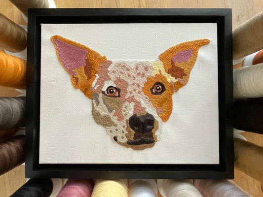 framed custom pet portrait chainstitch embroidered commission of a red cattle dog on a white canvas framed in a black frame